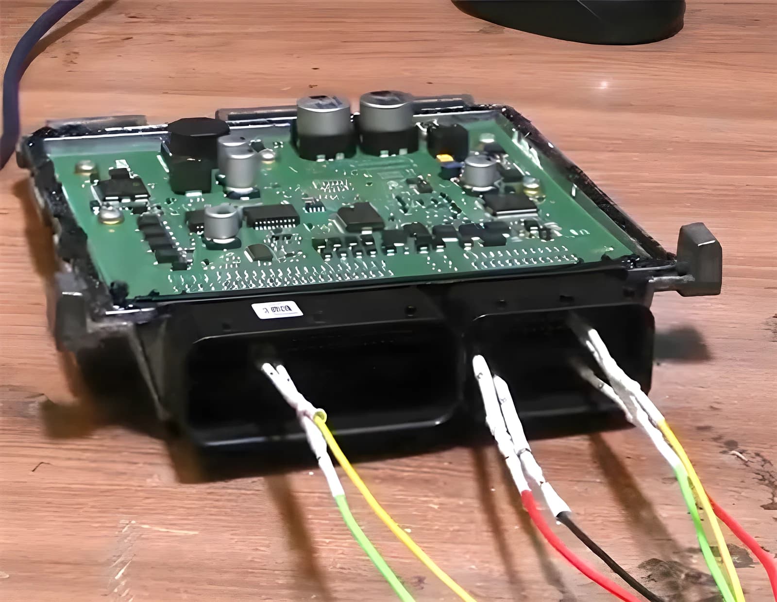 Real Continental SIM271DE2.0 Mercedes engine ECU opened on the bench with programming probe wires connected